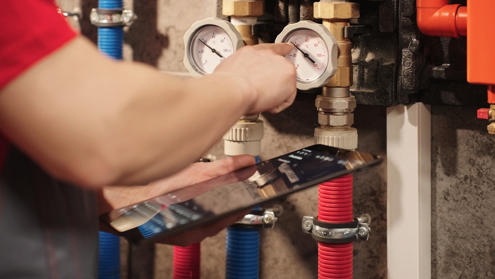 HVAC technician providing emergency heating service during a nighttime furnace repair at a residential home